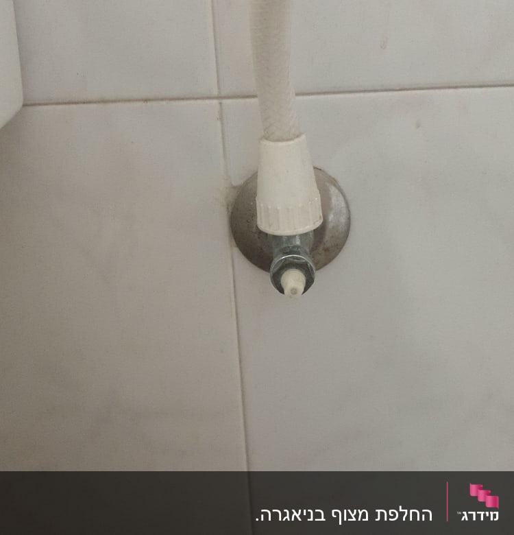 צינור מים מחובר לברז על קיר קרמיקה